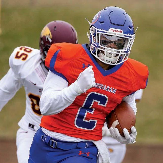 Marauders football player running with football and breaking away from defender.